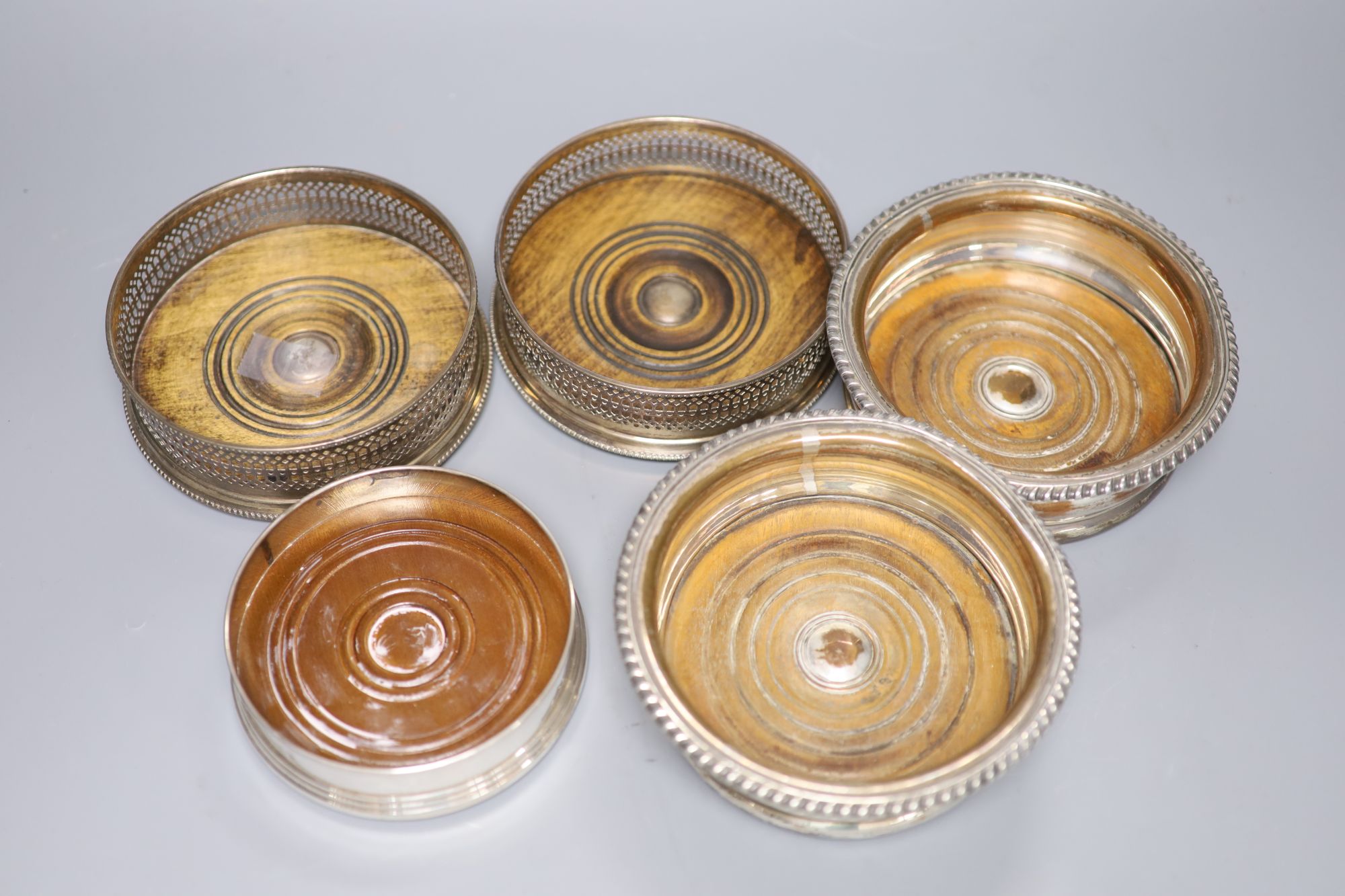 A pair of modern silver wine coasters, 13.2cm, one other modern silver coaster and a pair of plated coasters.